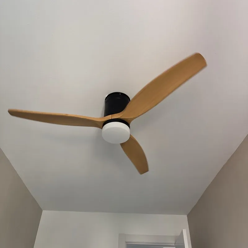 Ventilador de techo de madera con luz instalado en un dormitorio